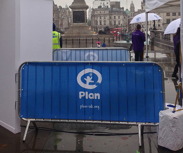 Plan UK logo on a blue fence scrim